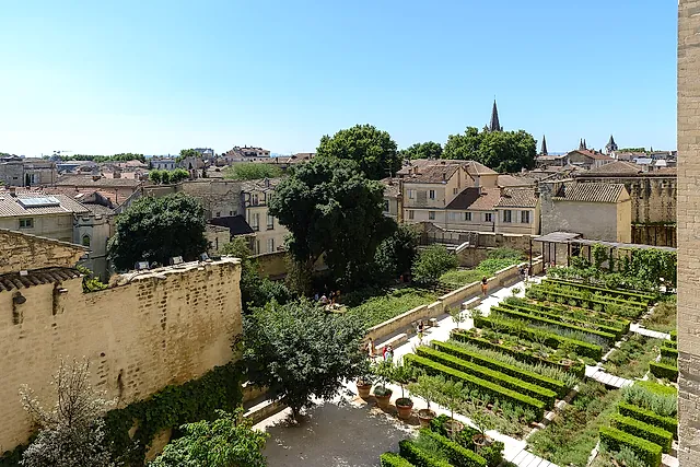 Le aiuole a terrazze dei giardini pontifici viste dall'alto, con i tetti di Avignone oltre il muro