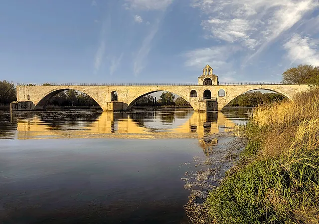 El Puente de Aviñón con luz dorada y la capilla de Saint-Nicolas sobre el puente, reflejada en el Ródano