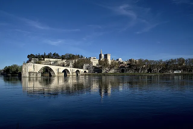 El Puente de Aviñón y, al fondo, el Palacio de los Papas al otro lado del Ródano bajo un cielo azul intenso